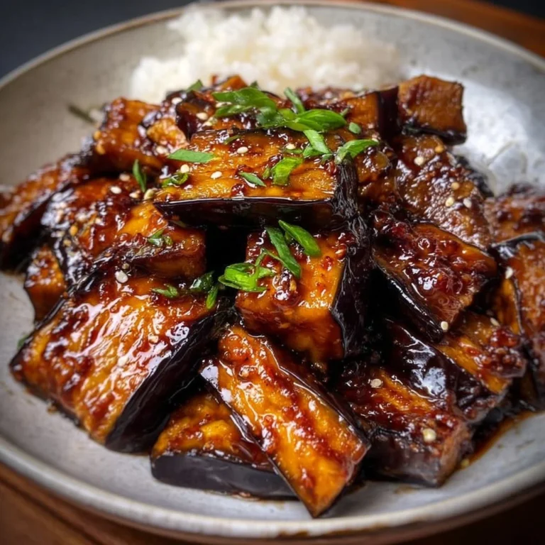 Miso glazed eggplant dish garnished with sesame seeds and green onions