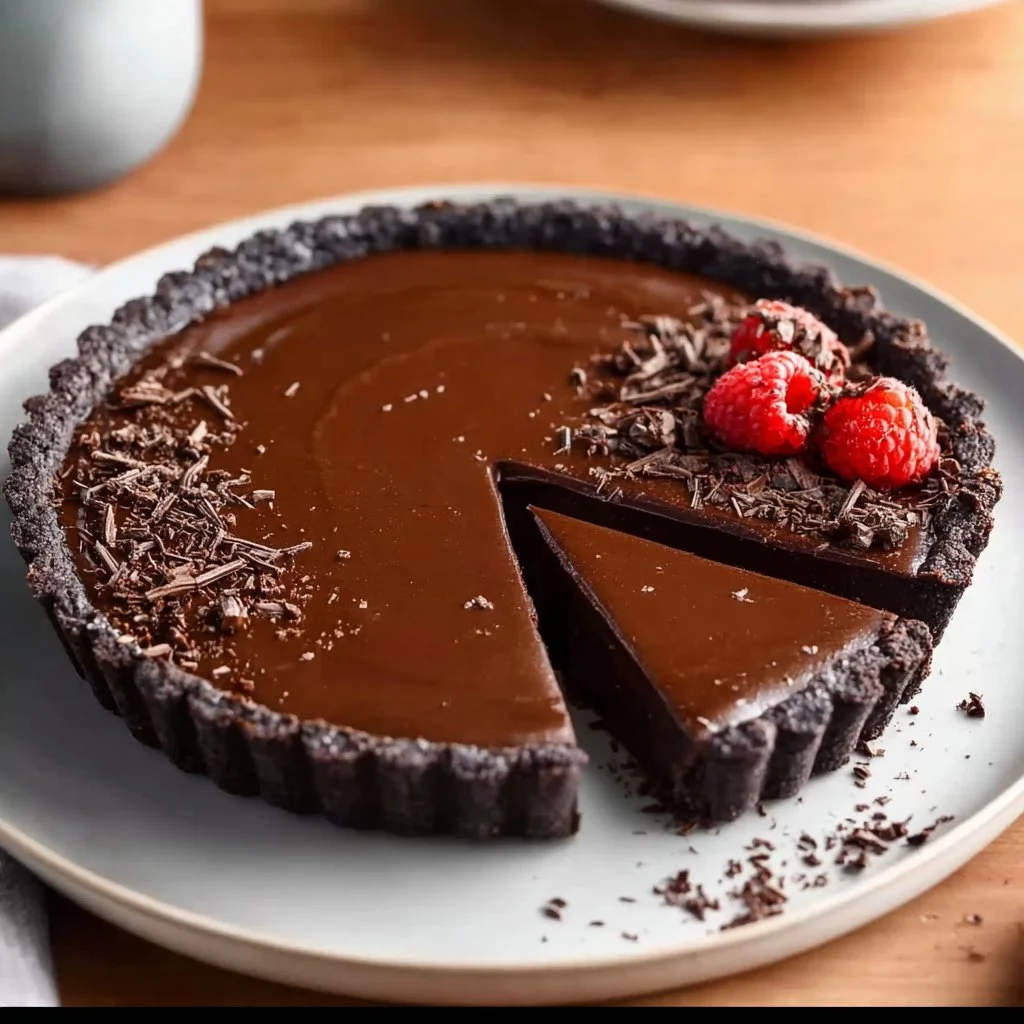 No-bake vegan chocolate tart topped with fresh berries.