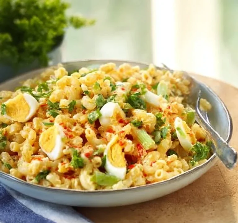 Delicious macaroni egg salad served in a bowl with garnishes.